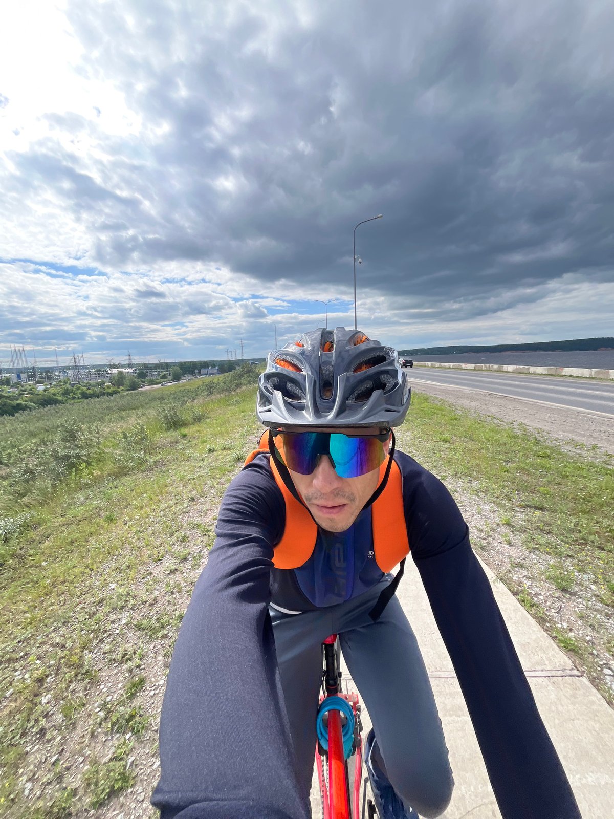 Cyclist rides riverside path in Chaikovsky, Russia