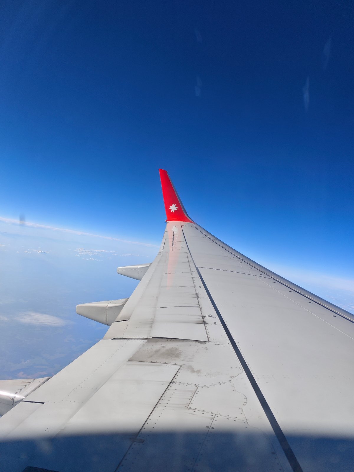 Passengers document aerial views during commercial flight over water
