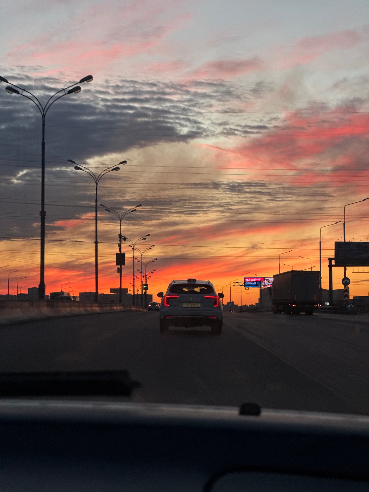 Sunset sky over Dzerzhinsky highway, shot from a moving vehicle