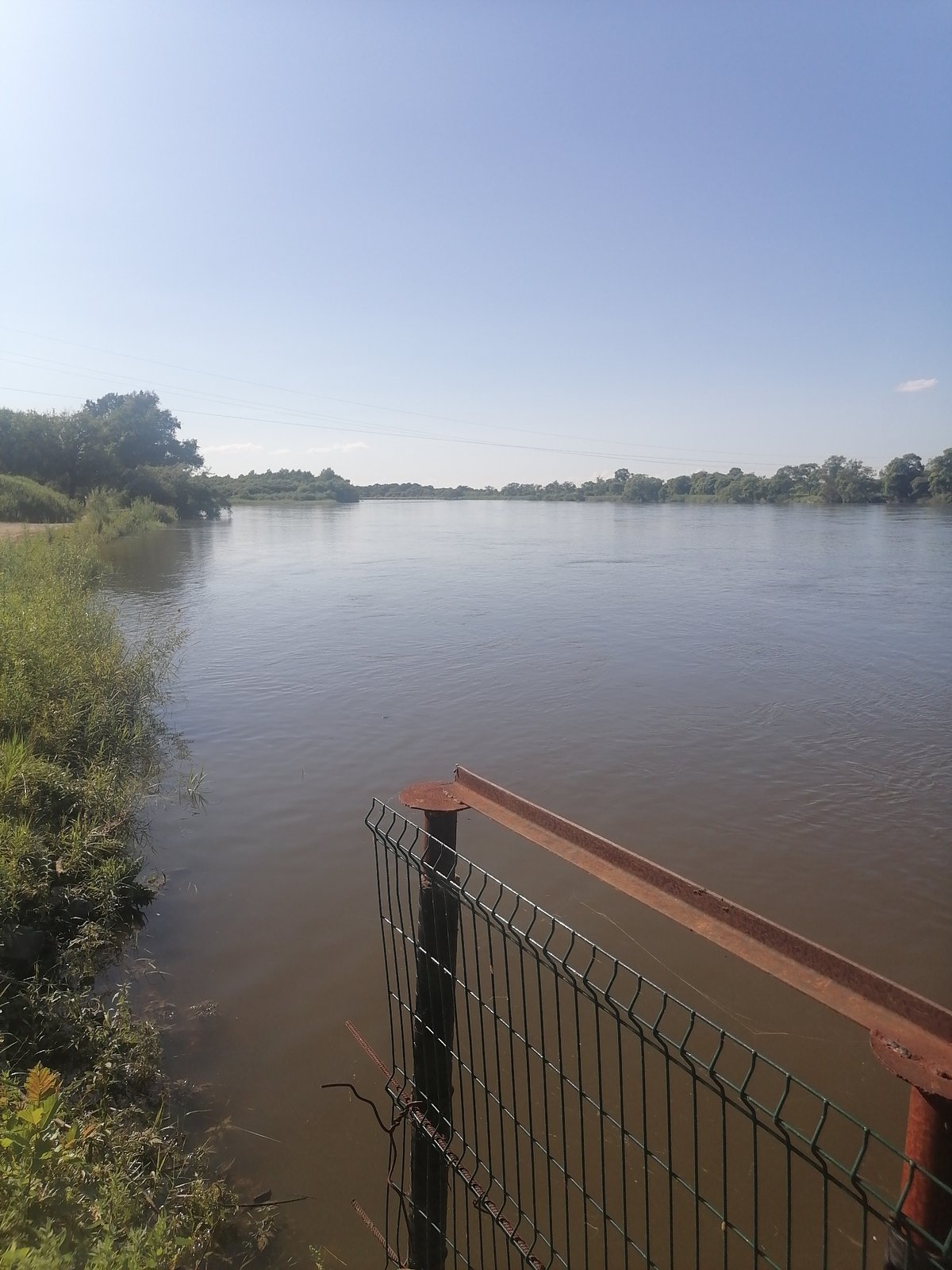 Riverside stop in rural Russia with a dog and a bridge