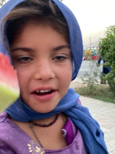Girl enjoys watermelon in Kandahar
