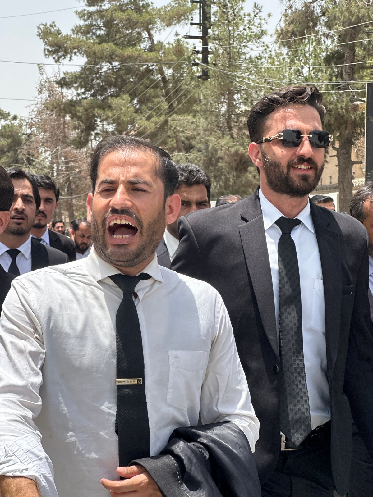 Formal procession, likely lawyers, marching through Quetta streets