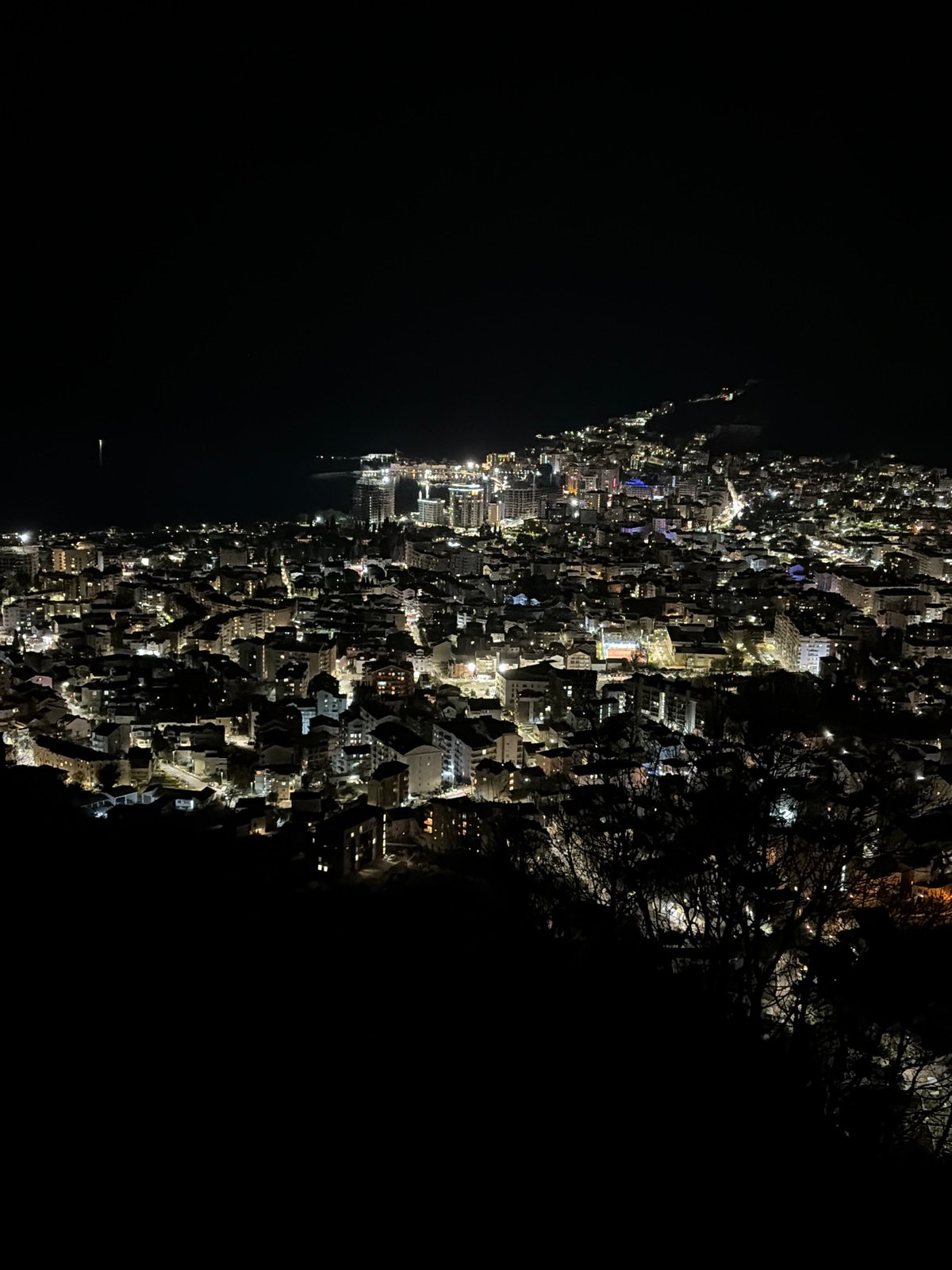 Nighttime aerial view captures illuminated Budva, Montenegro cityscape