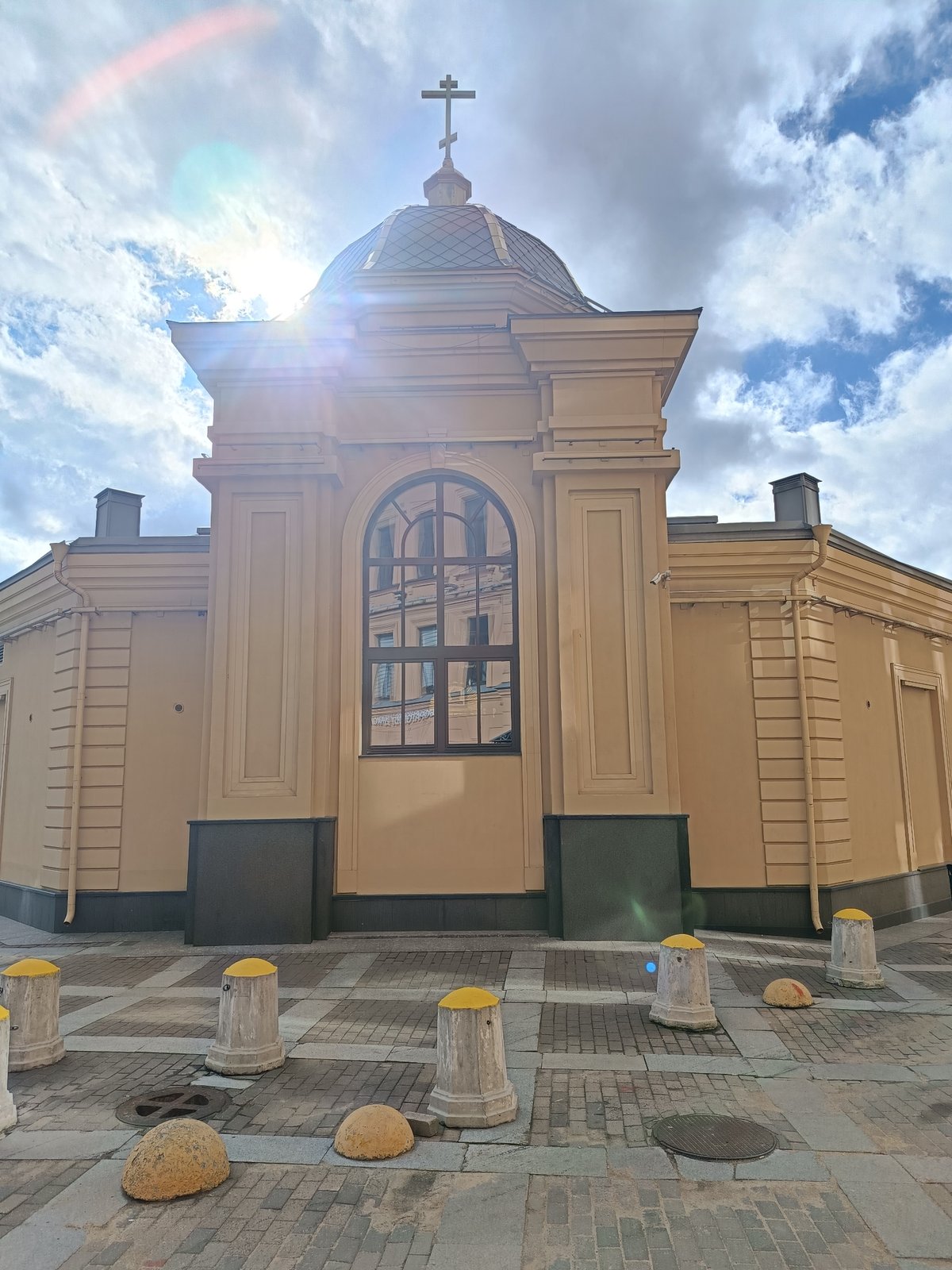 Religious building with cross-topped dome observed in urban area