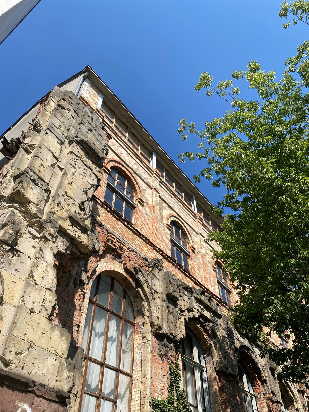 Scarred brick building in Warsaw, history written on its walls
