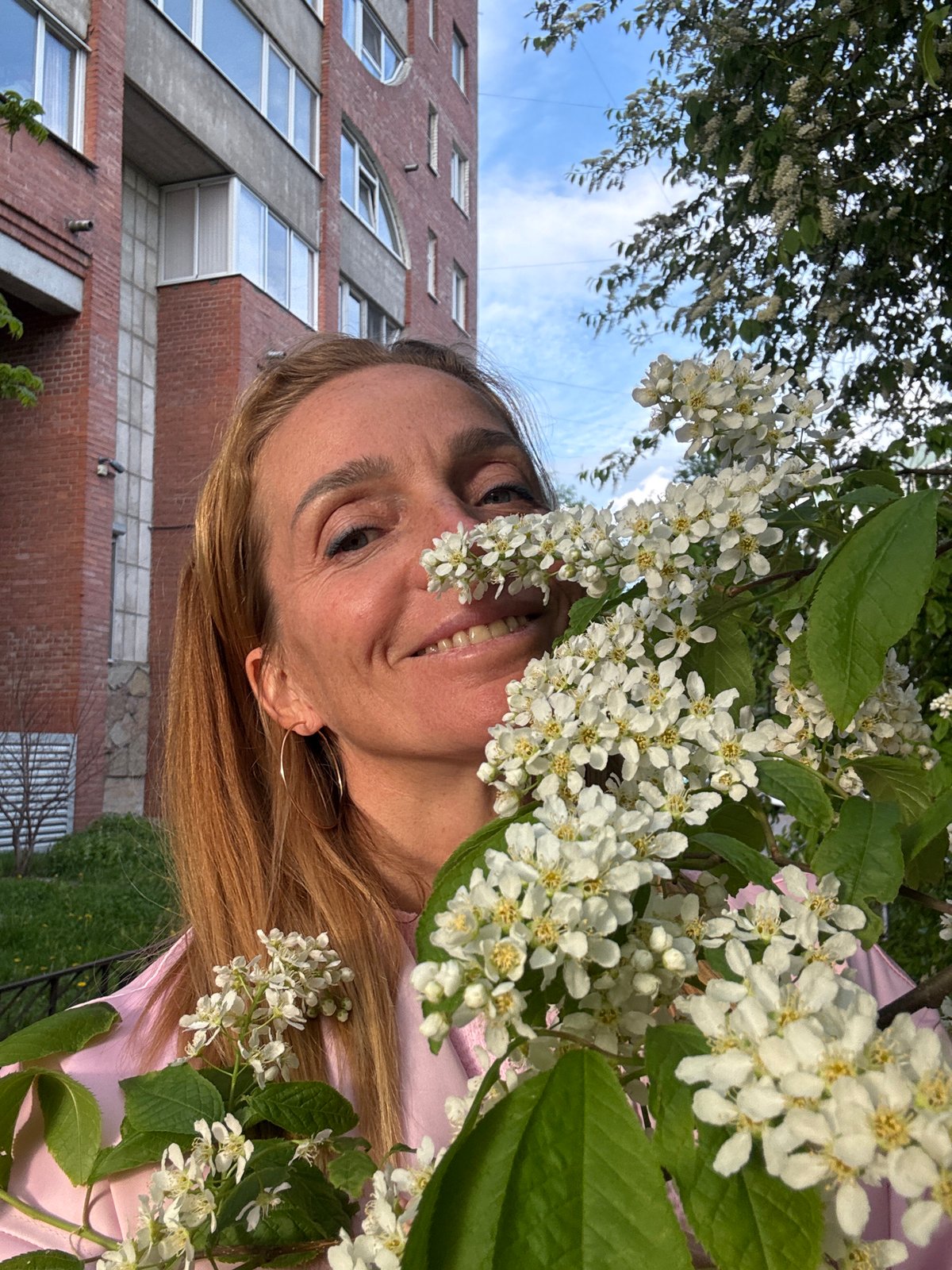 Woman photographed among blooming trees in Saint Petersburg