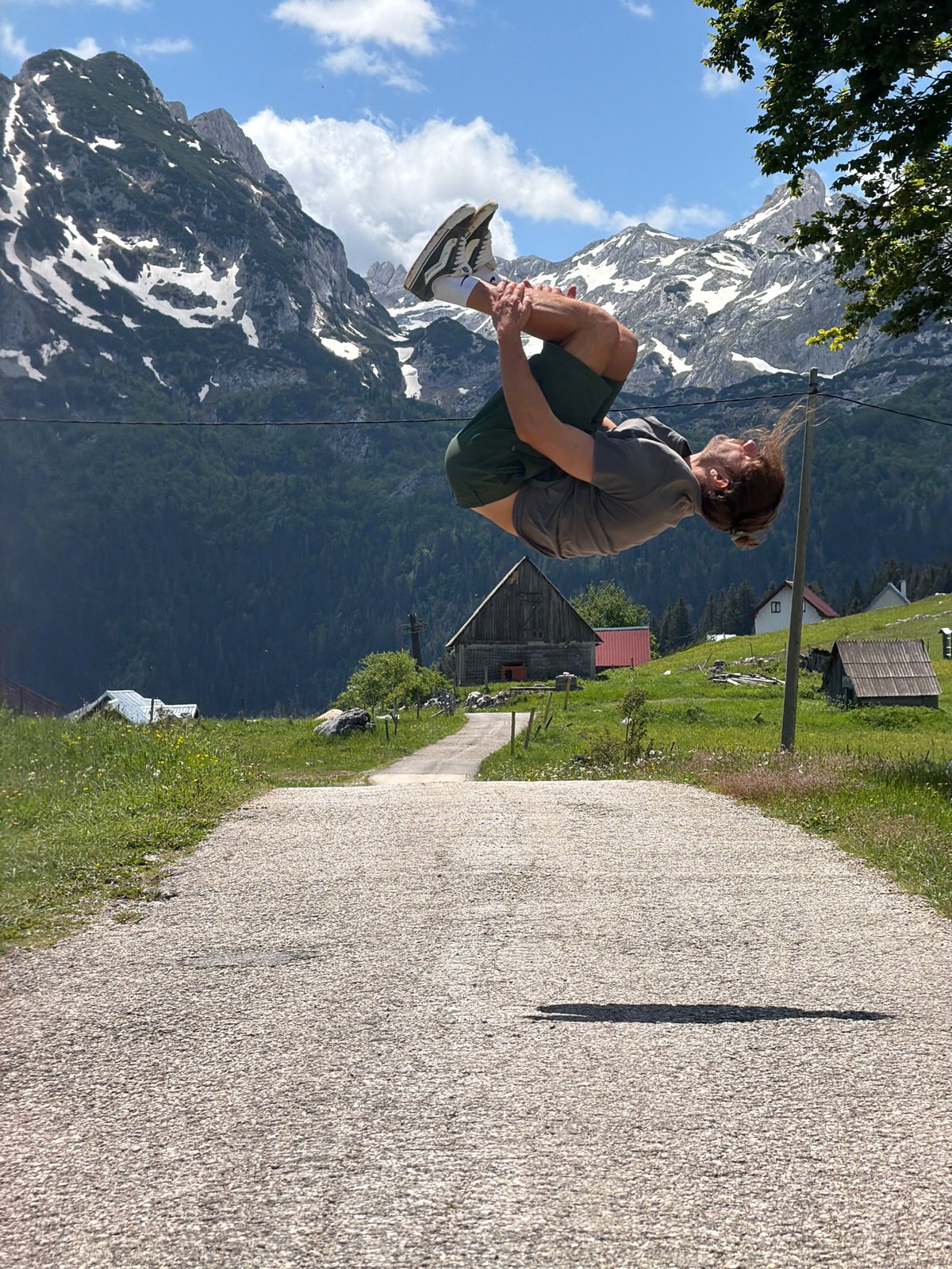 Young man captured mid-leap in Montenegro mountain landscape