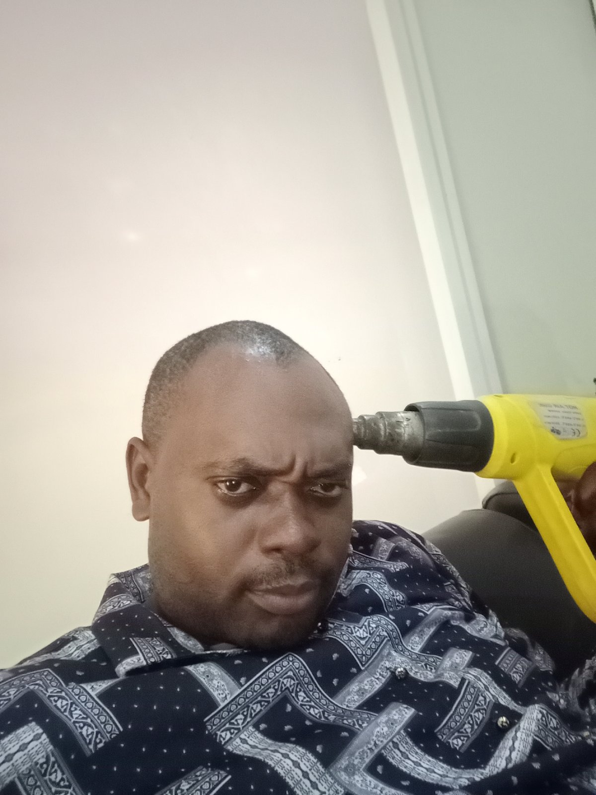 Man uses heat gun on forehead in Nigerian home