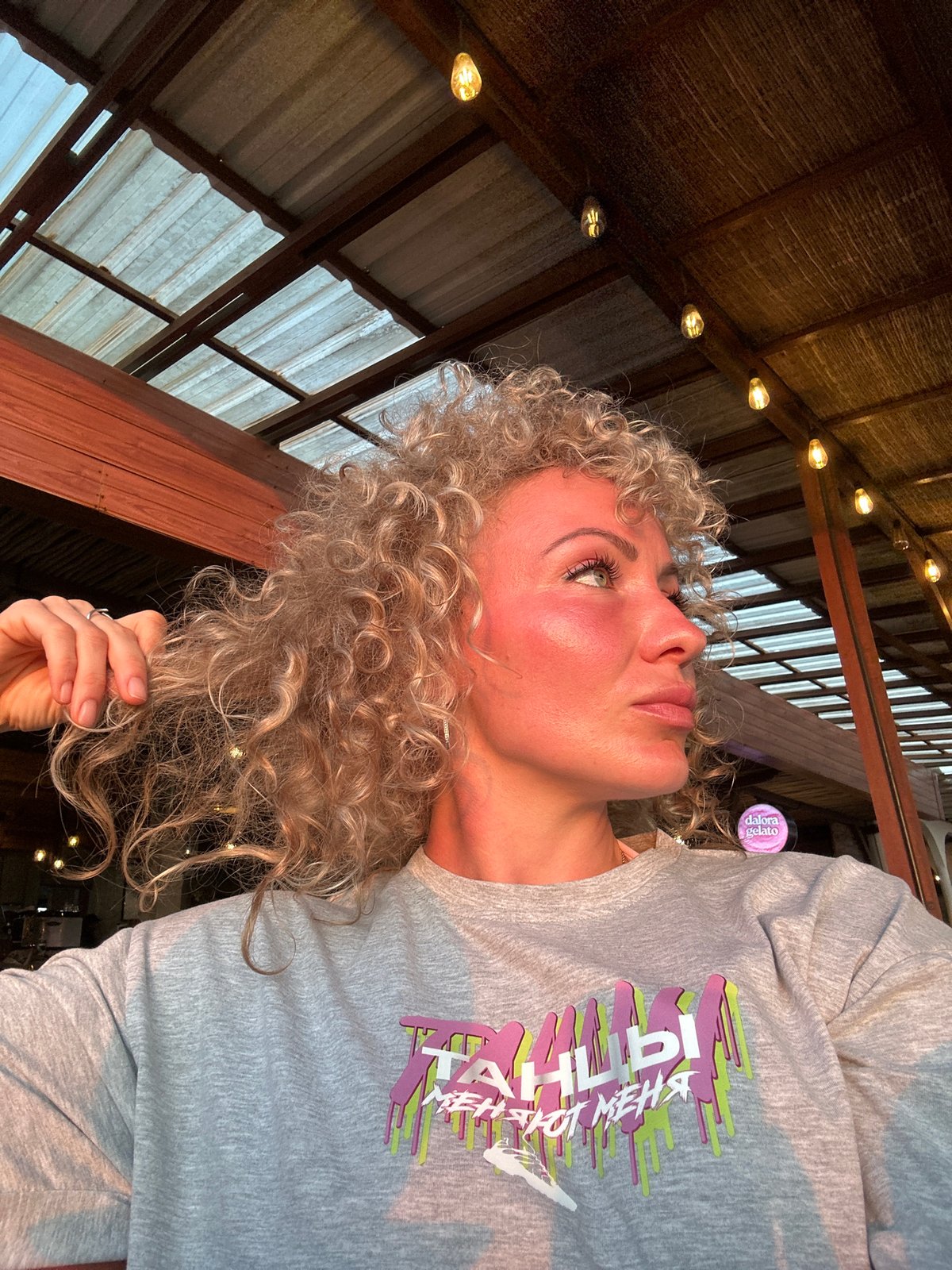 Blonde woman captured in golden light, looking upward