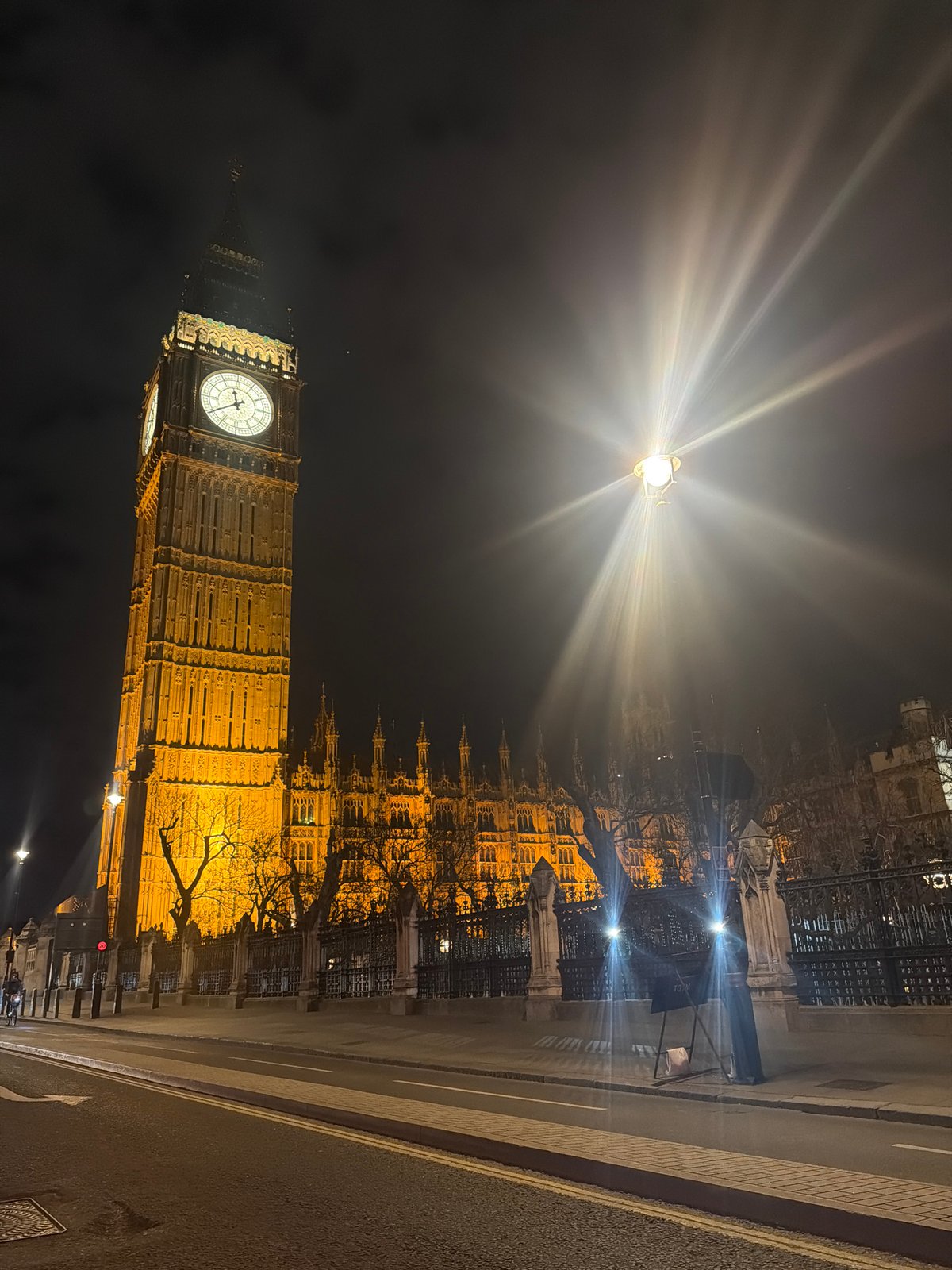 Big Ben illuminated at night as London traffic passes