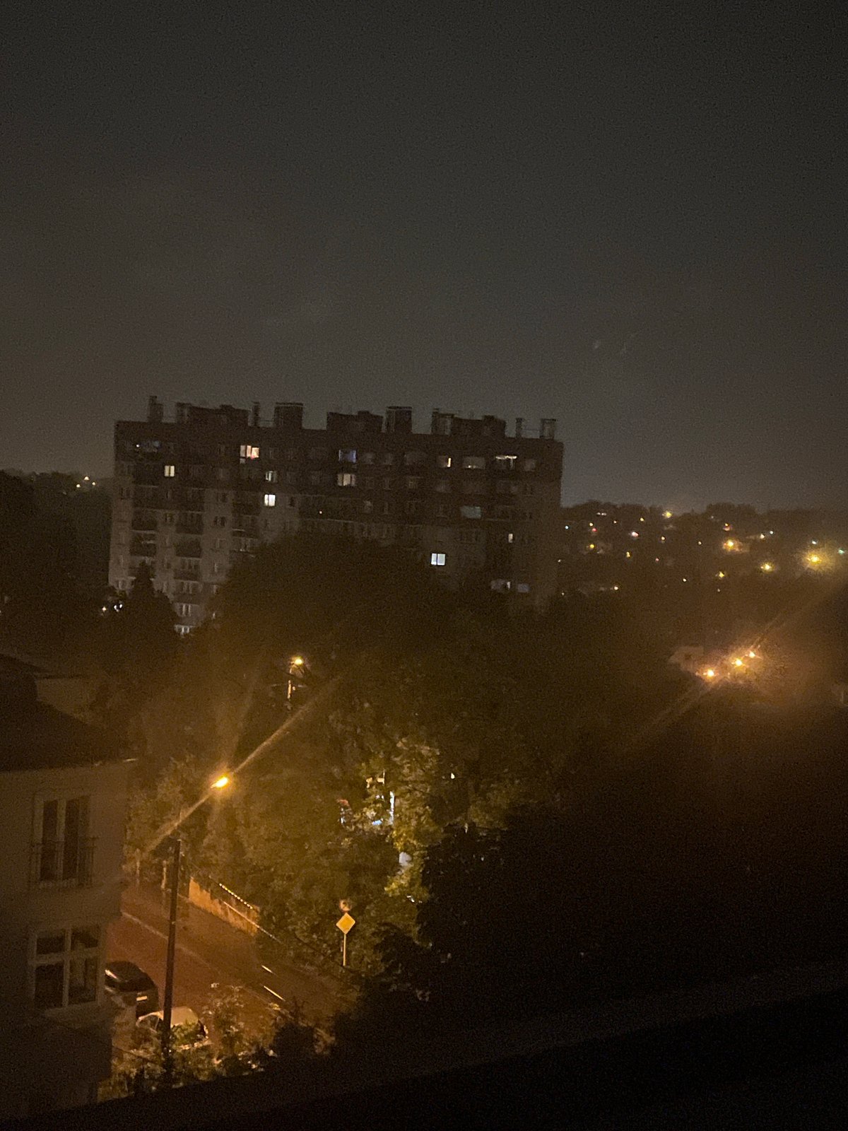 Rainy night cityscape from balcony vantage point