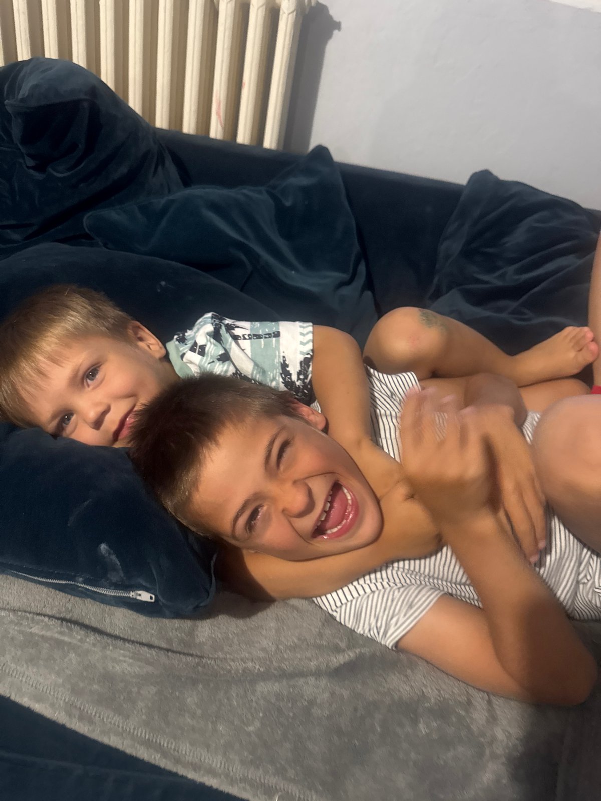 Kids relaxing and playing together on the couch at home