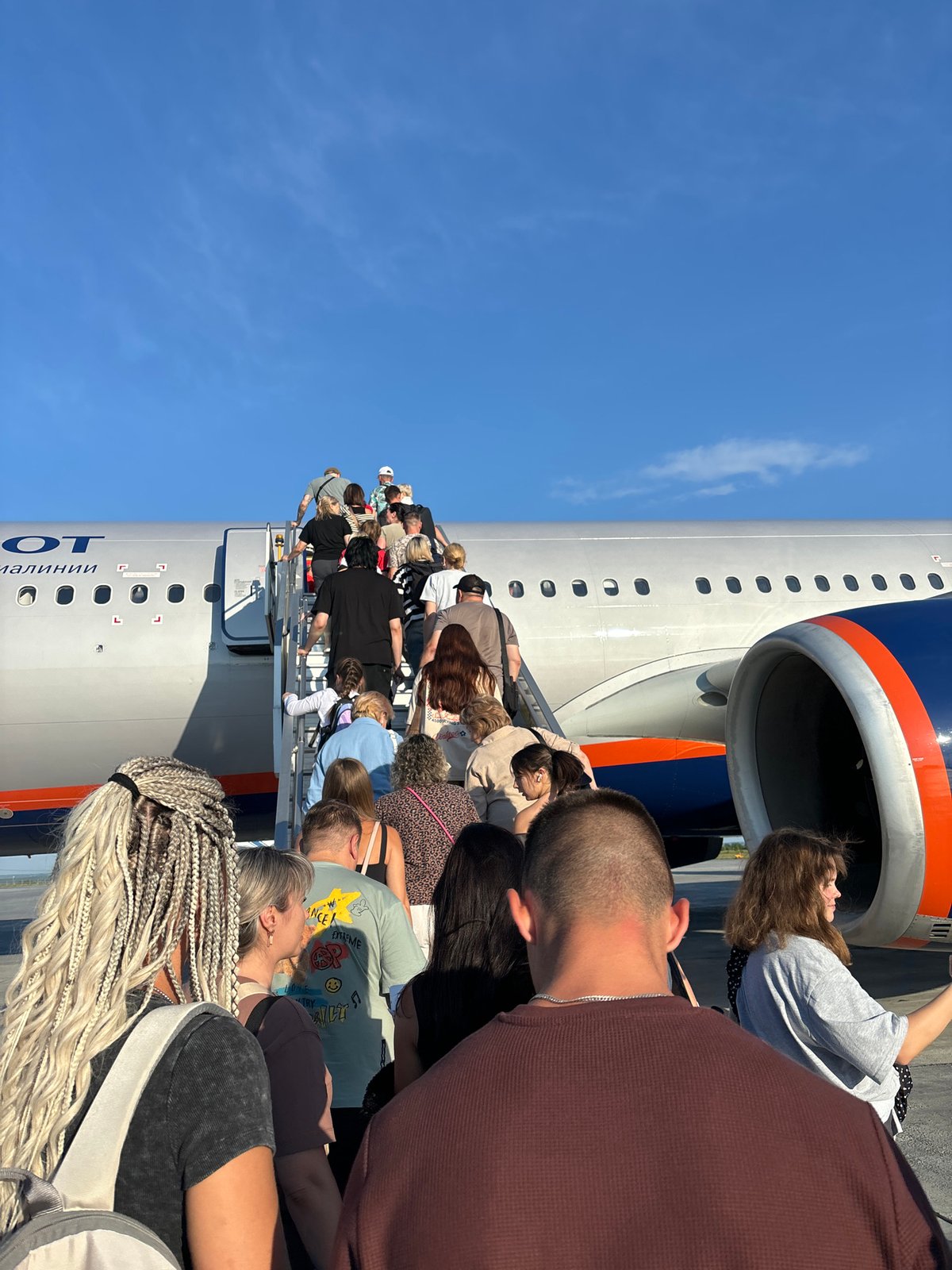 Passengers board an Aeroflot jet on a sunny Russian tarmac