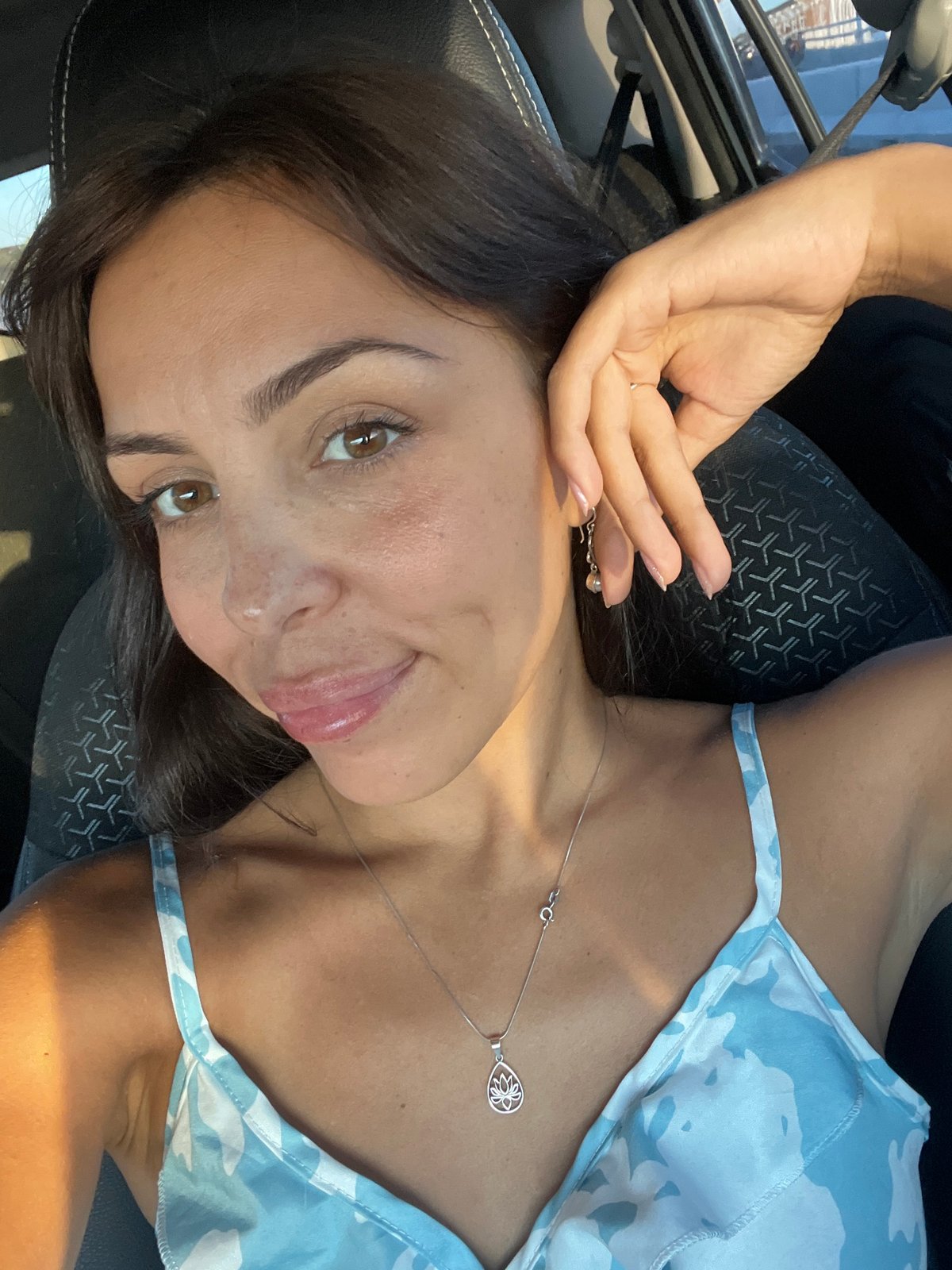 Woman photographs herself during morning car journey in Kuta Selatan