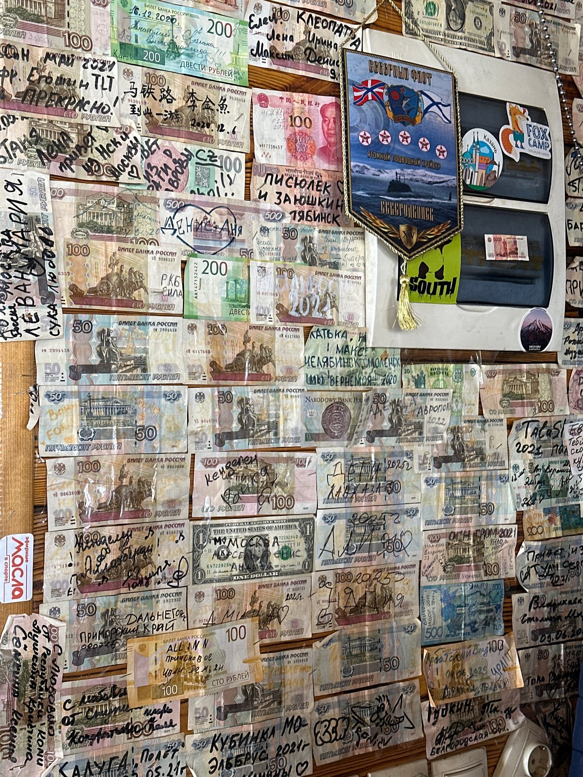 Bar wall in Terskol covered in signed banknotes from travelers