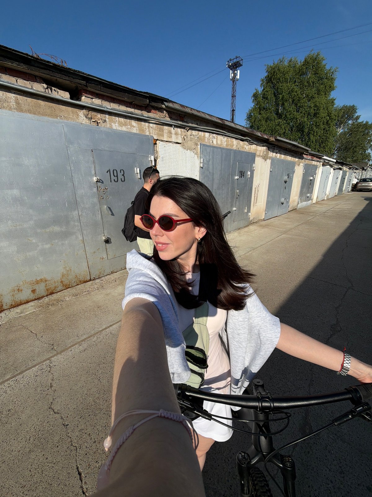 Bike ride selfie under a blue sky with red sunglasses