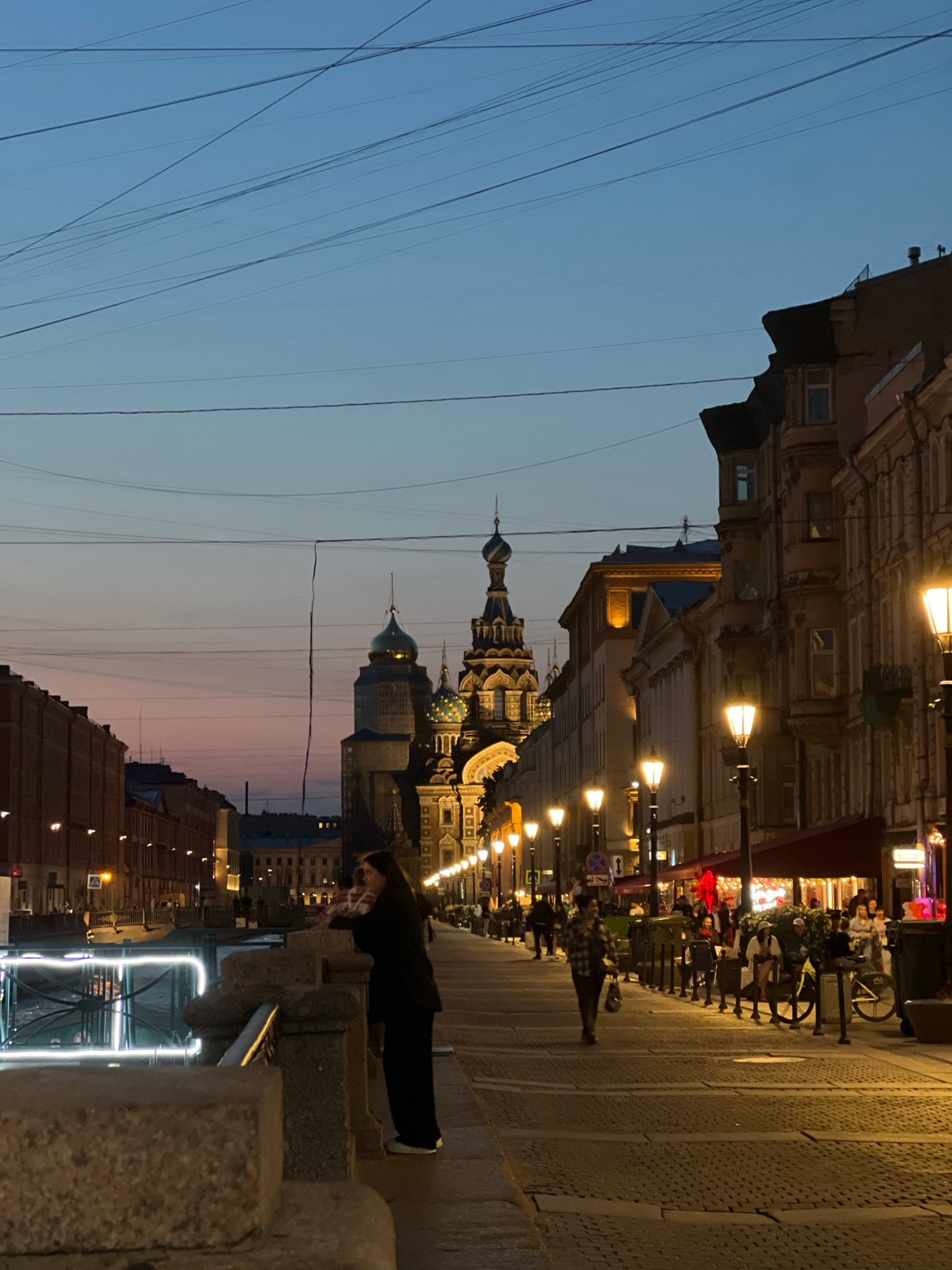 Leaning on a canal railing at twilight in Saint Petersburg
