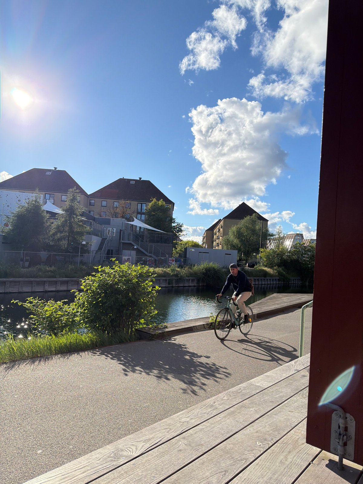 Cycling along a sun-drenched canal path in Copenhagen