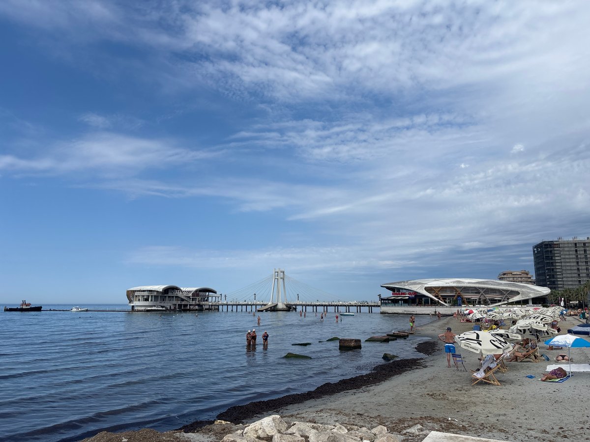 Sunny morning at Durrës beach, with a wet dog nearby.