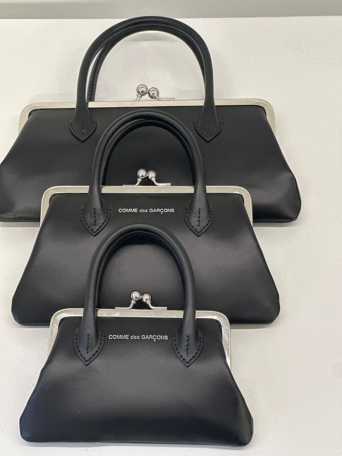 Three black handbags photographed in central London