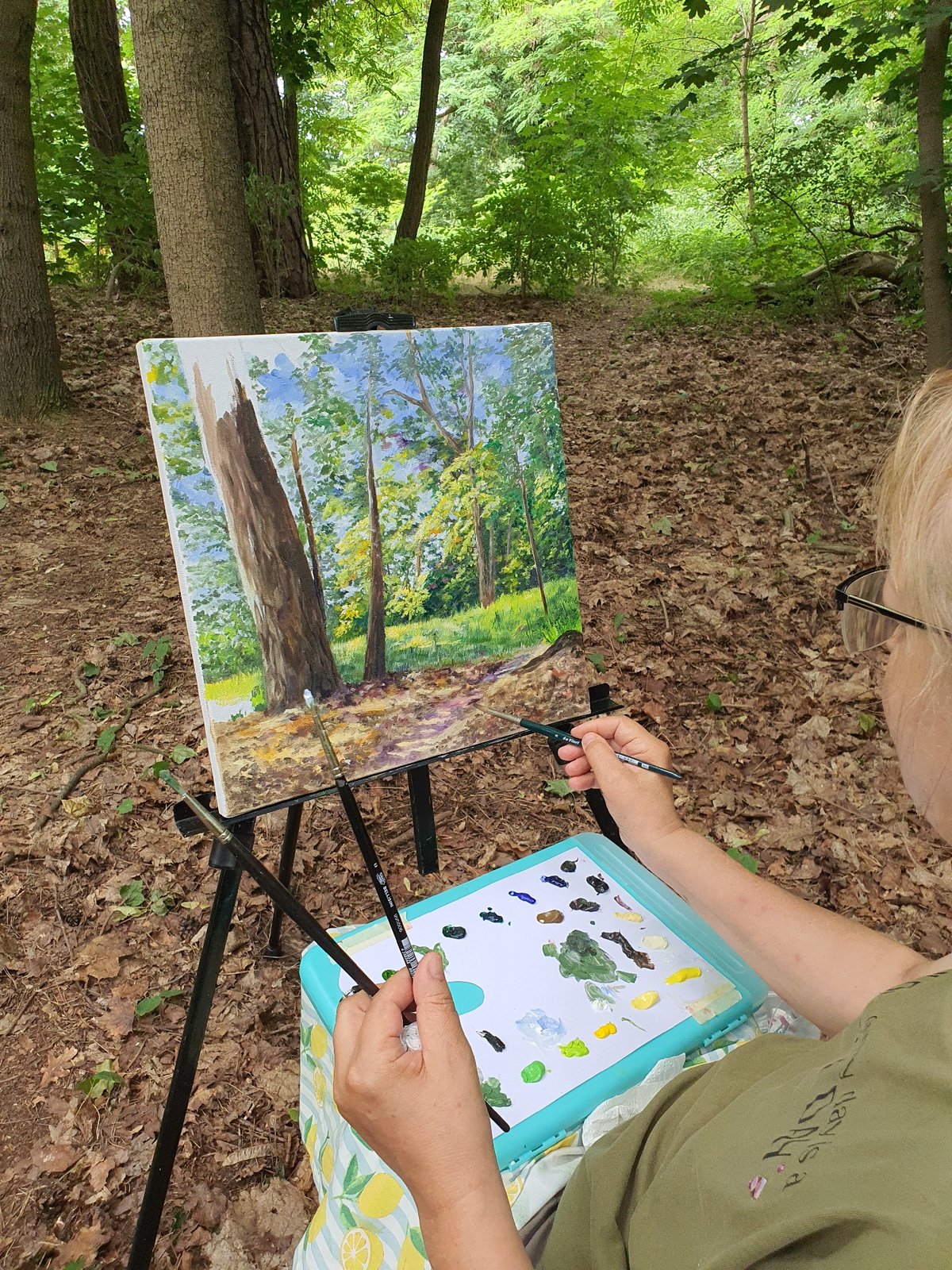 Plein air painting session along a forested path in Falkensee
