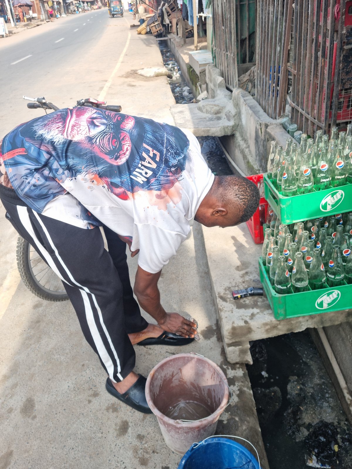 Cyclist performs bike maintenance on concrete surface