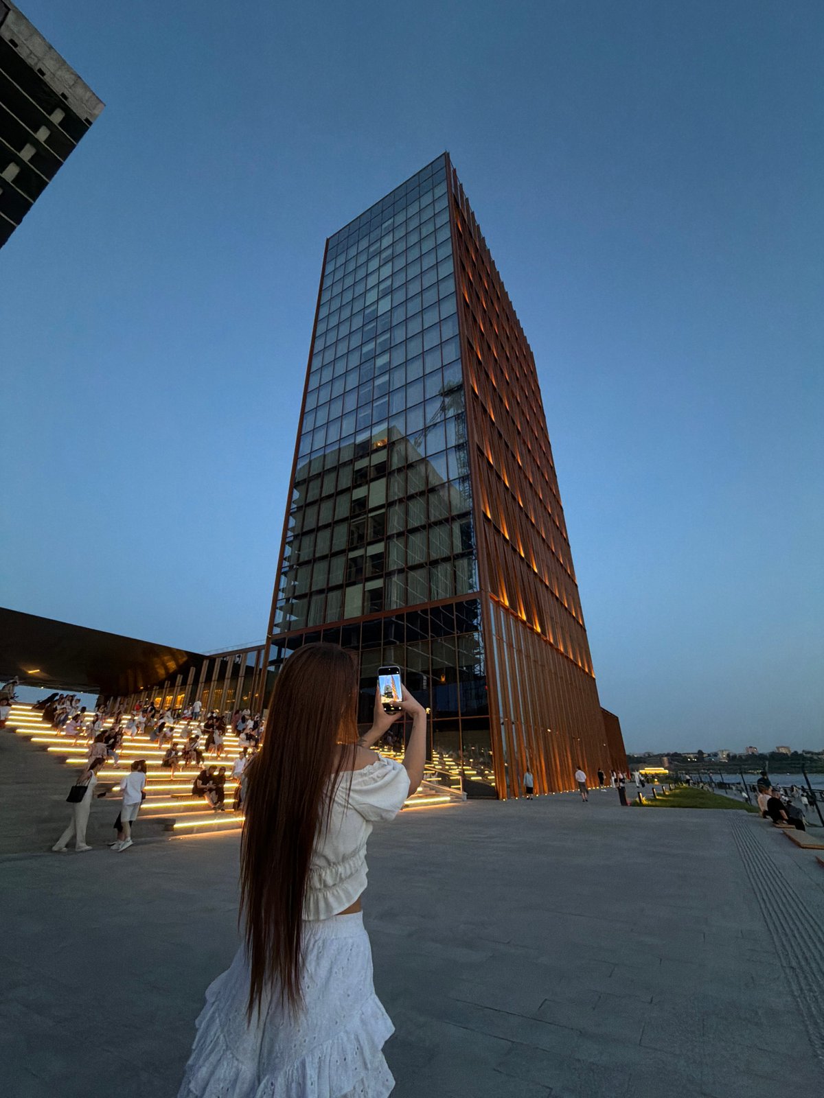 Woman photographs modern building in Kazan public square