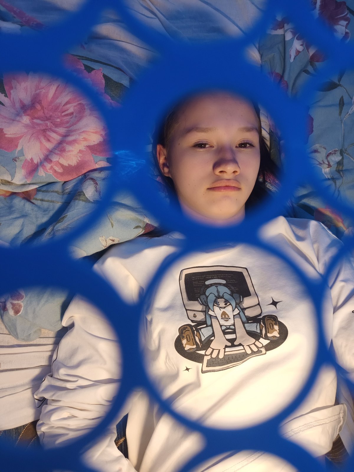 Young person photographed resting through mesh screen in Ольховка