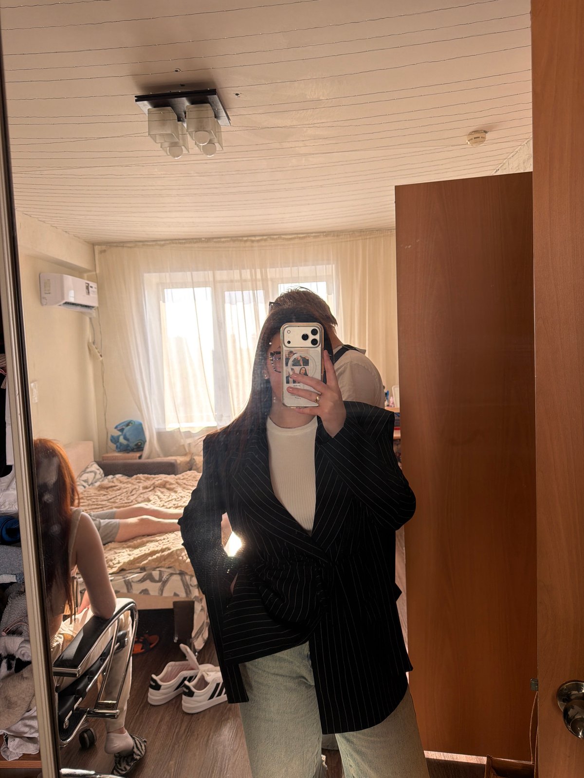 Person takes mirror selfie in Izhevsk bedroom