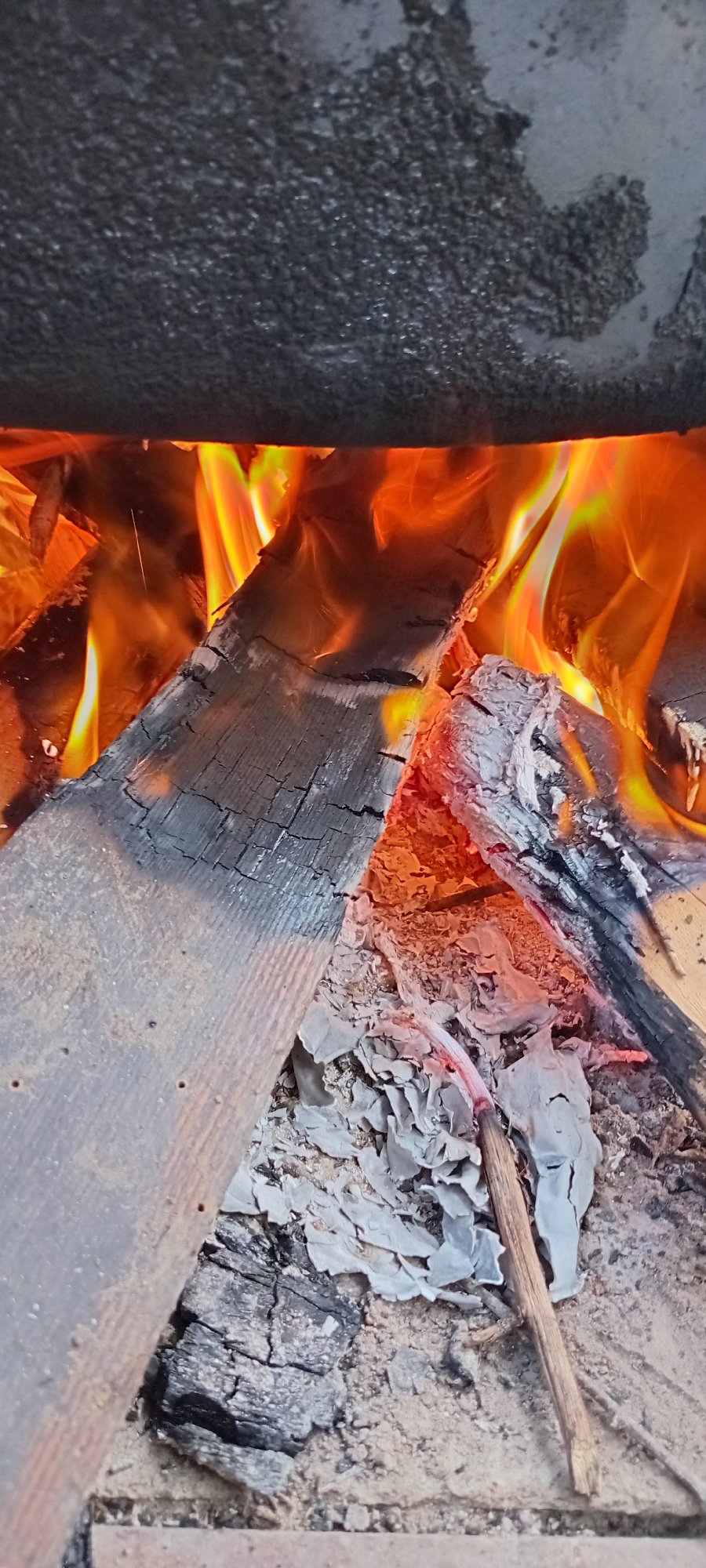 Open fire burning under a large pot outdoors