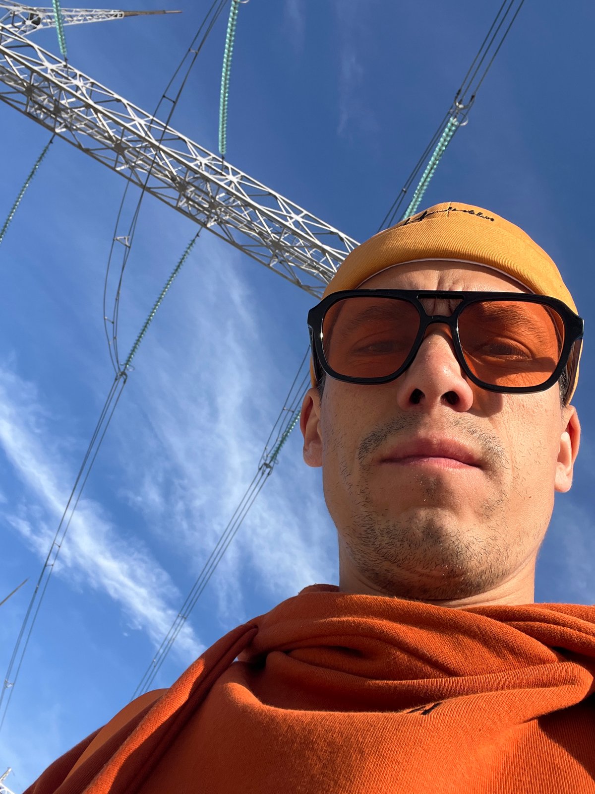 Person photographed from below against blue sky in Chaikovsky