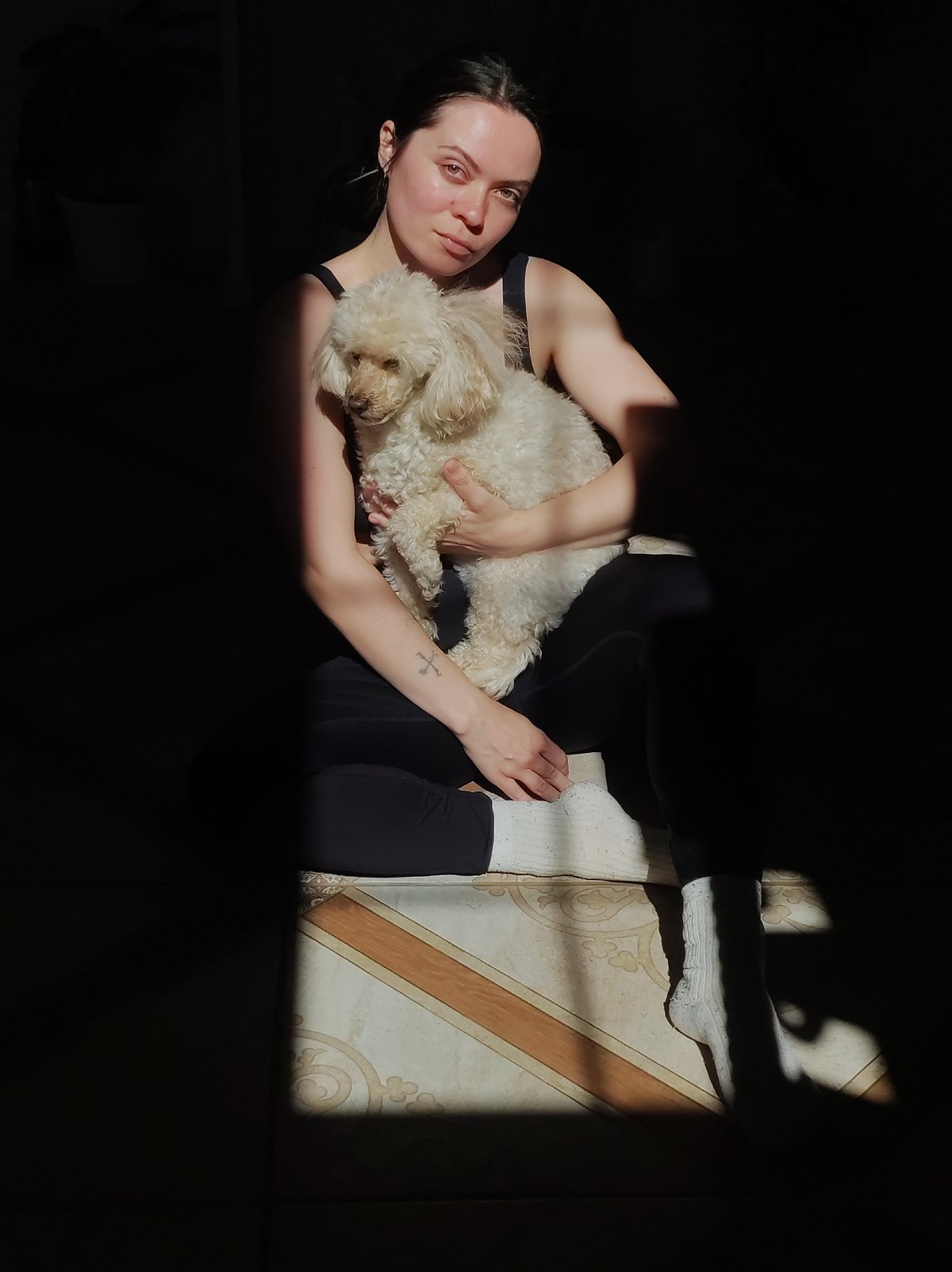 Woman and white poodle documented in quiet morning moments