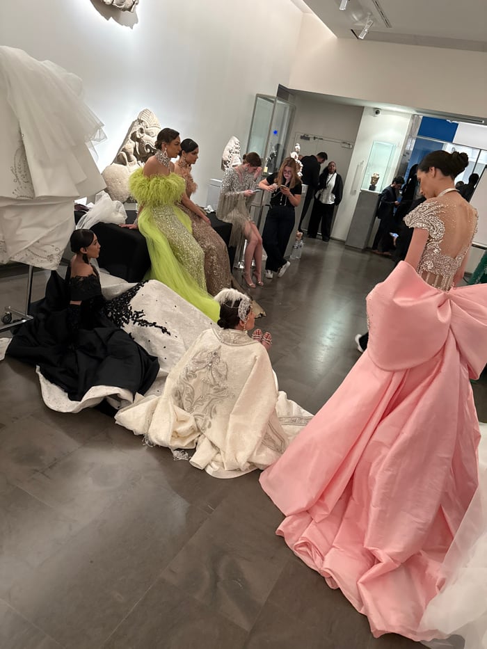 Fashion models prepare for photoshoot in elaborate gowns in Paris