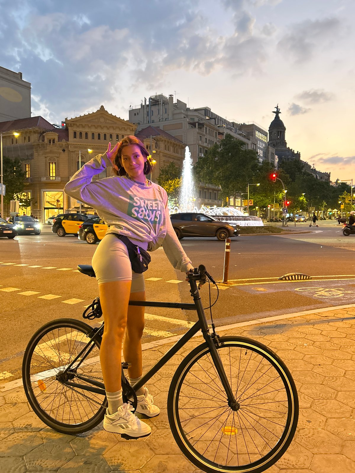 Woman with bicycle spotted at Barcelona intersection during dusk