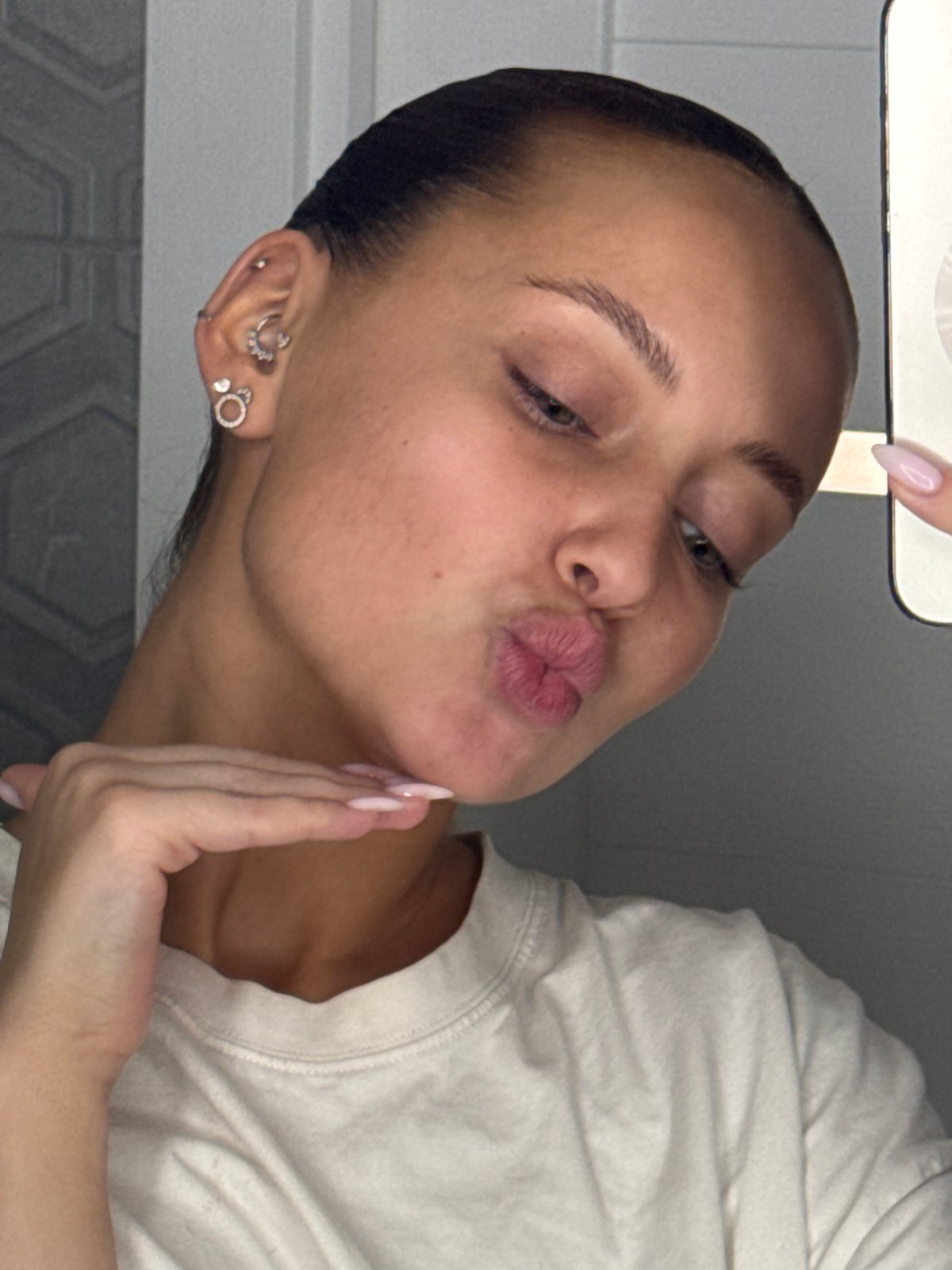 Woman poses with cosmetics in Chaikovsky bathroom early morning