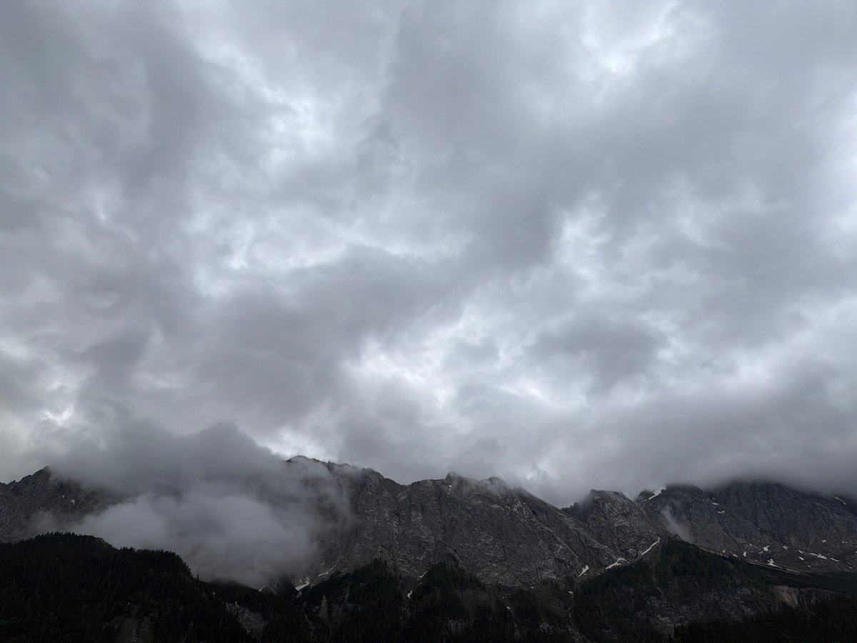 Morning clouds shroud rocky peaks in Grainau, Germany