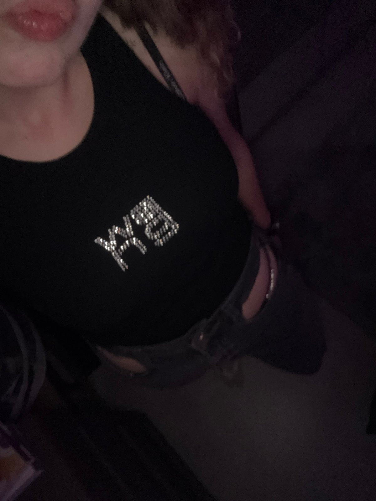 Person in rhinestone-embellished black top photographed indoors in Turin