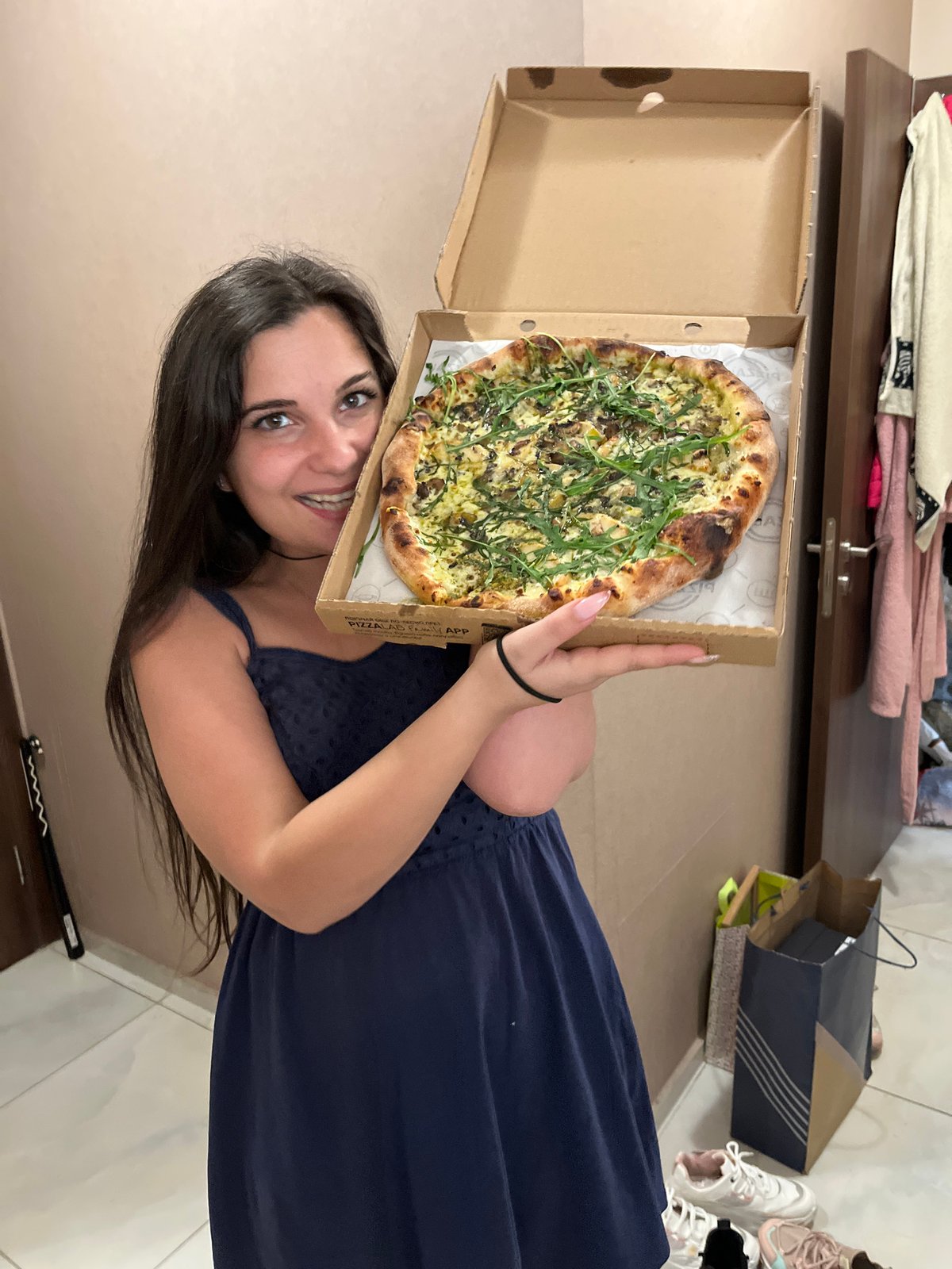 Woman holds pizza with mixed toppings in Sofia