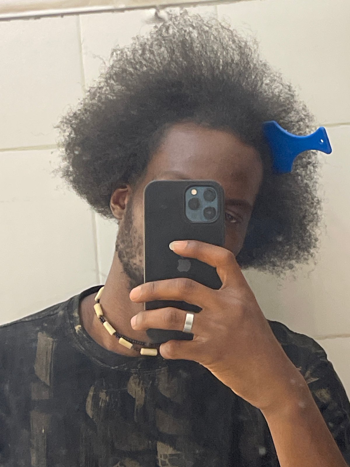 Person Takes Bathroom Selfie With Blue Comb In Hair