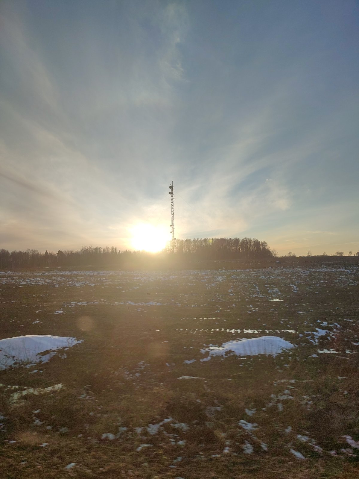 Spring thaw creates patchy landscape with melting snow, standing water