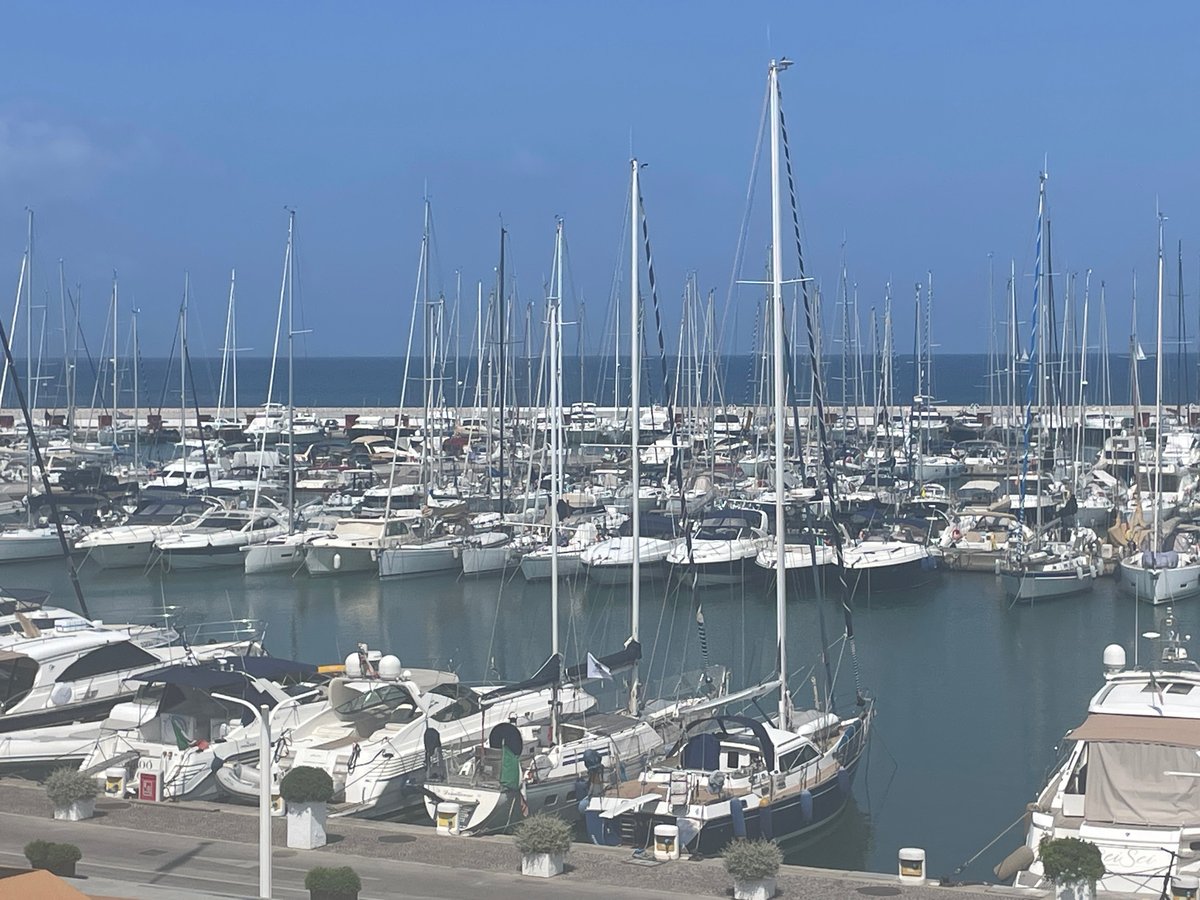 Sailboats and yachts fill Punta Ala's marina on a clear day