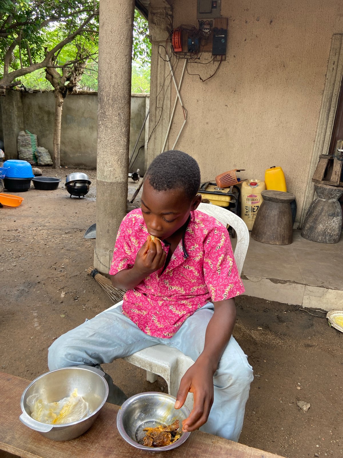 Young person eats outdoor meal in Mararaba, Nigeria