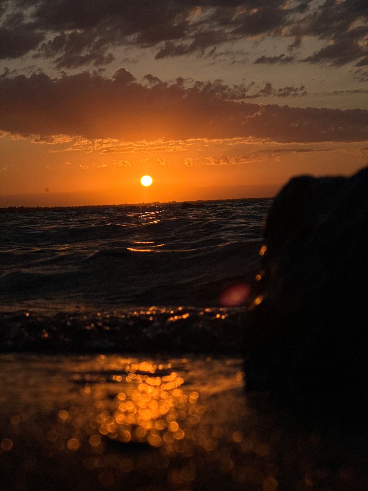 Sunset over a Kokshetau lake, orange light on the water
