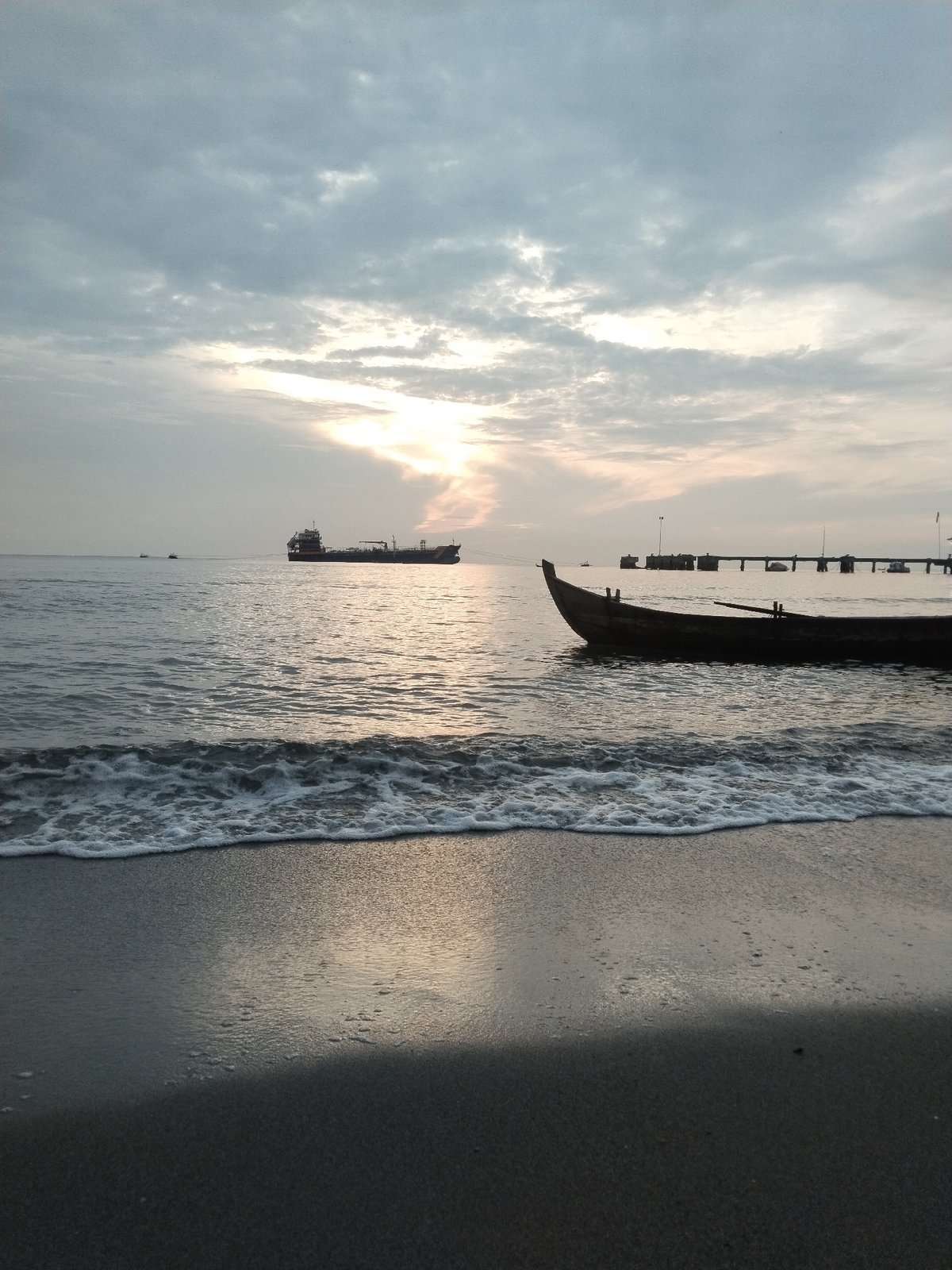 Sunset along the Lhokseumawe coast, boats and moody skies.