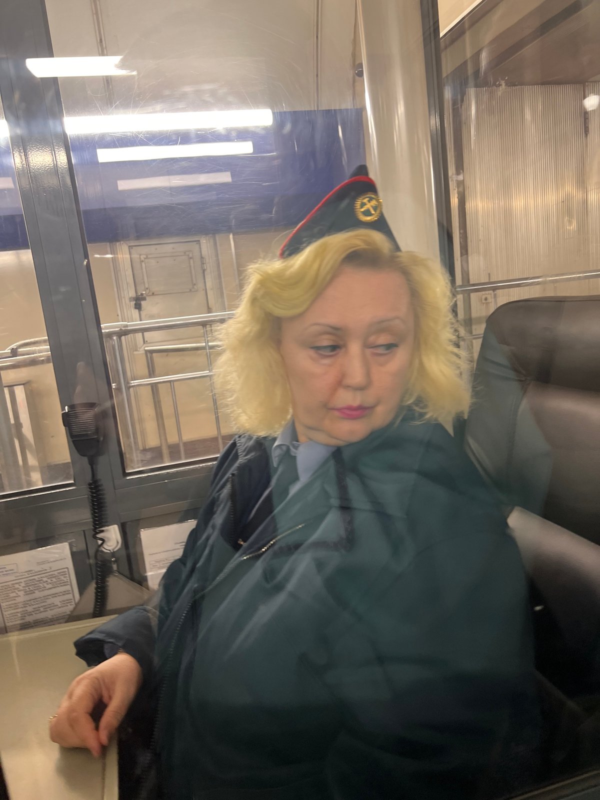 Woman in uniform observed behind glass window