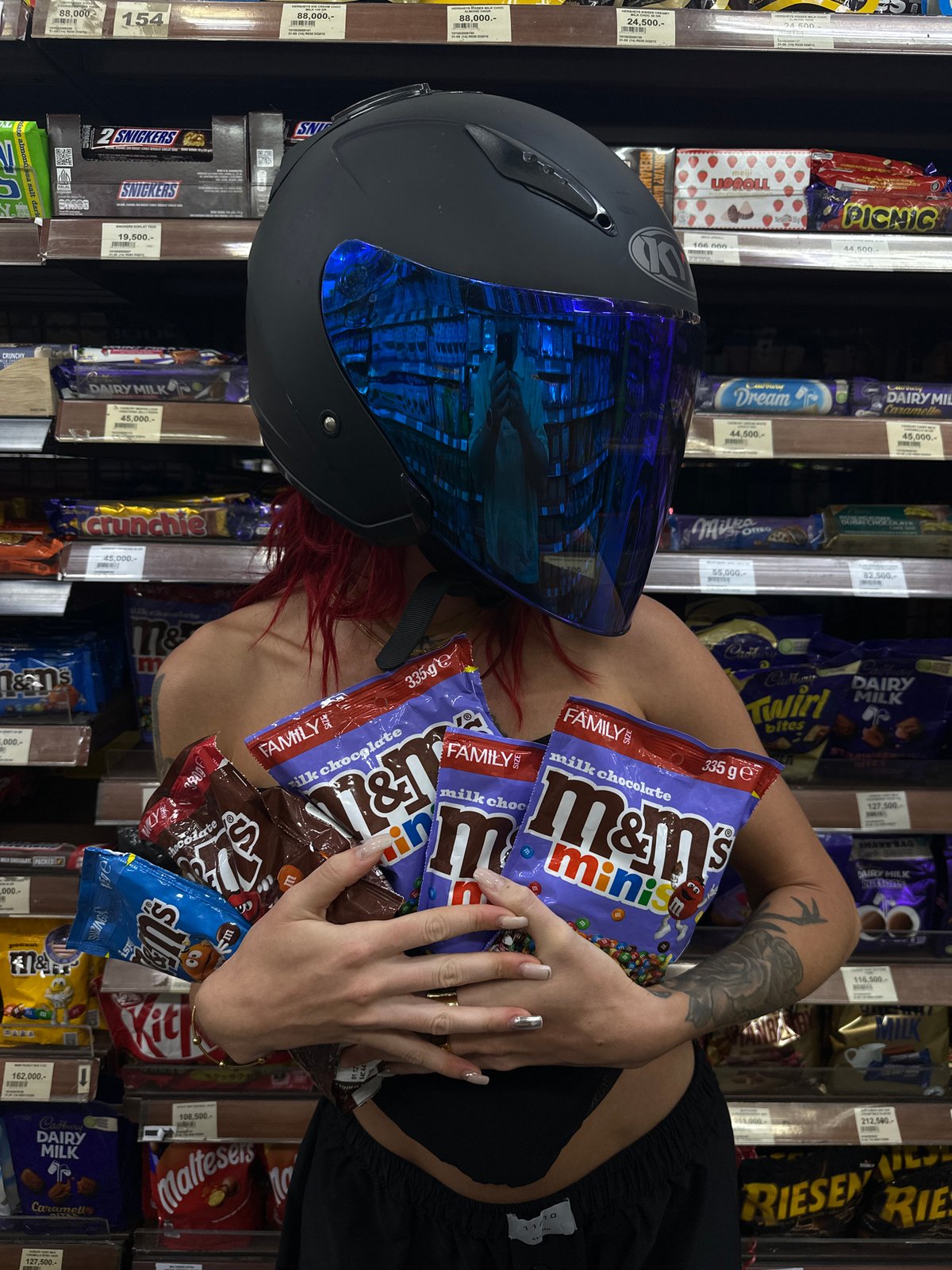 Helmeted motorcyclist goes candy shopping in North Kuta supermarket