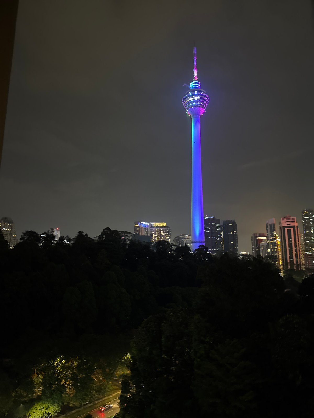 Nighttime gym workout session overlooks illuminated Kuala Lumpur skyline