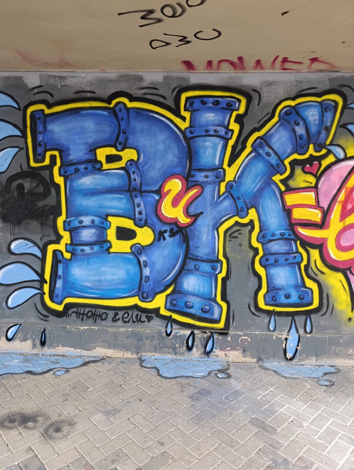 Blue pipe-styled graffiti mural documented with #UrbanTales tag