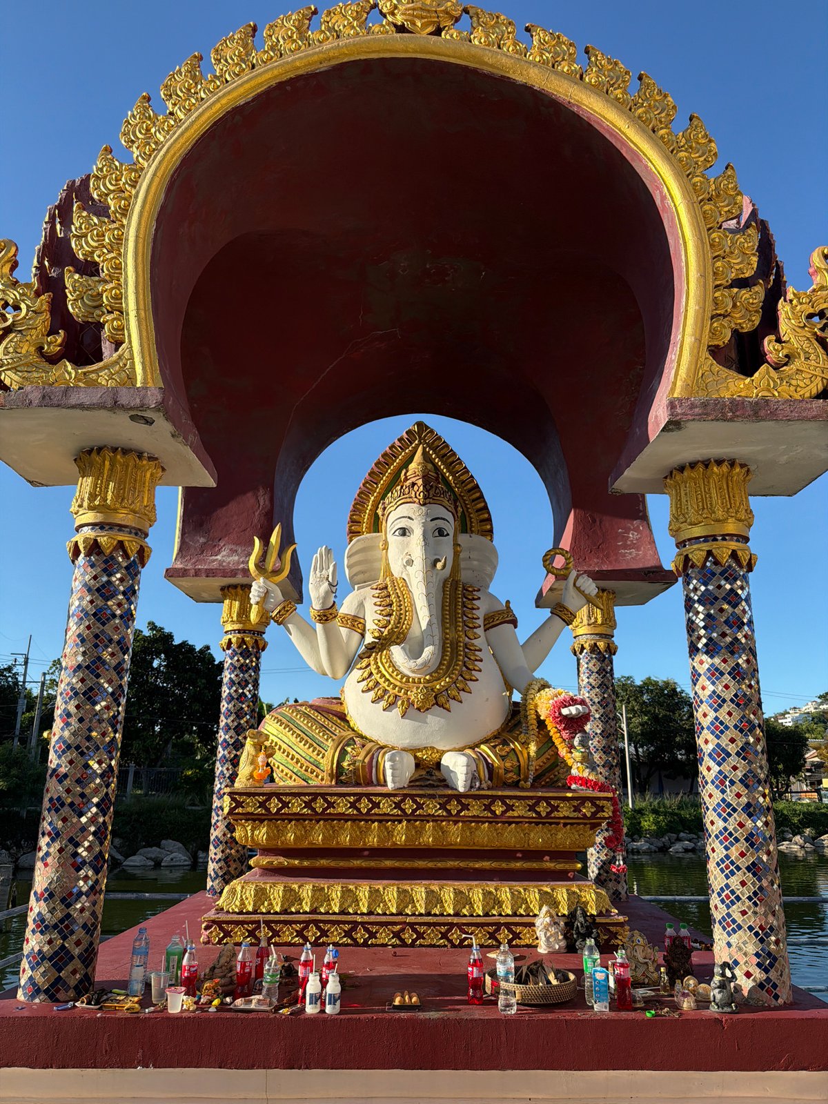 Temple visitor documents ornate statuary at Baan Plai Laem