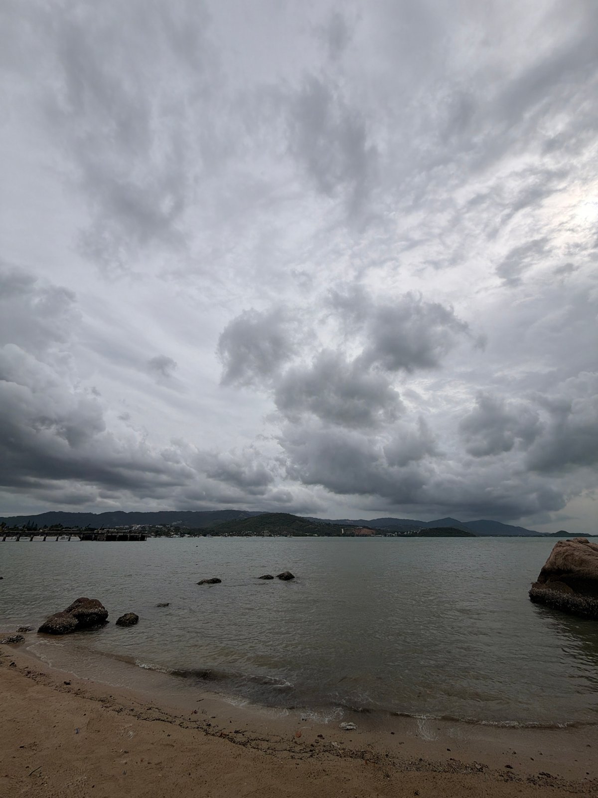 Cloudy morning on Ko Samui's coast, scooters and temple in view